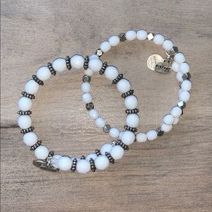 two white Alex And Ani bracelets
